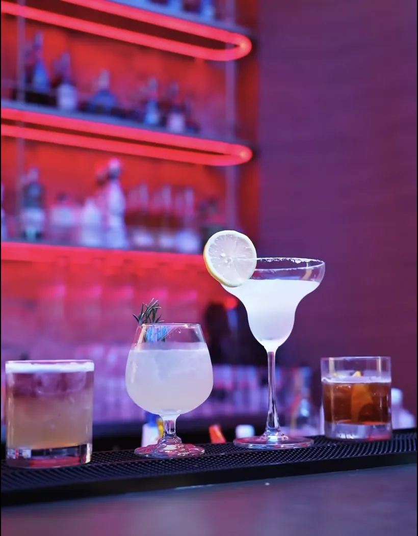 Cocktails on the bar counter under neon lights